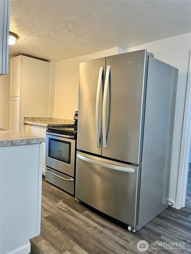 2122 15th St, Bremerton, WA 98312 - kitchen featuring appliances with stainless steel finishes, light countertops, dark wood-style flooring, white cabinetry, and a textured ceiling