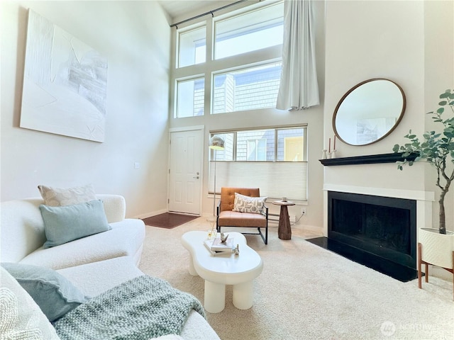 7309 Sand Point Way NE Unit B727, Seattle, WA 98115 - carpeted living room featuring baseboards, a fireplace with flush hearth, and a towering ceiling