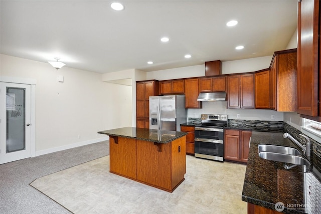 14431 22nd Avenue Ct E, Tacoma, WA 98445 - kitchen with a kitchen island, dark stone counters, under cabinet range hood, a sink, and appliances with stainless steel finishes