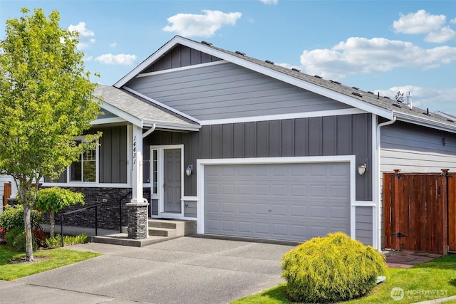 14431 22nd Avenue Ct E, Tacoma, WA 98445 - view of front of property with board and batten siding, driveway, a garage, fence, and a shingled roof