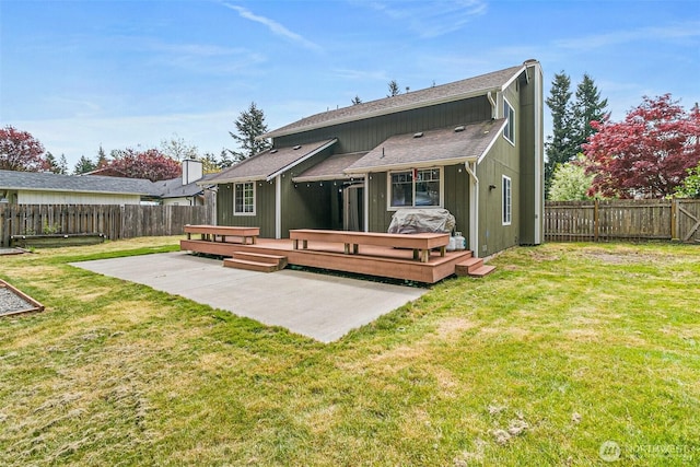 rear view of house with a fenced backyard, a yard, a patio area, and a deck