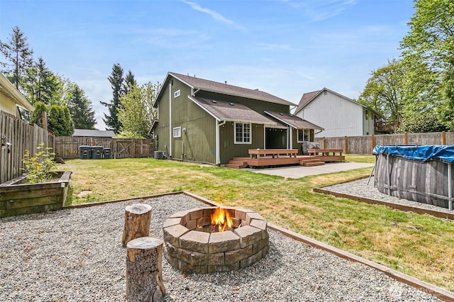 back of house with a fire pit, a deck, cooling unit, a fenced backyard, and a fenced in pool