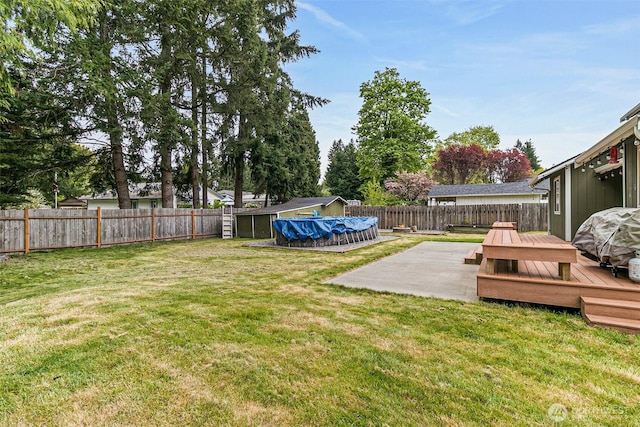 view of yard with a fenced backyard, a fenced in pool, a deck, and a patio