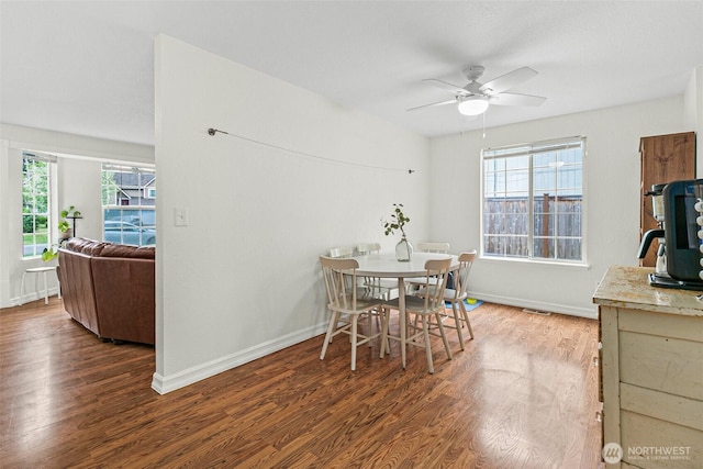 dining space with baseboards, ceiling fan, and wood finished floors