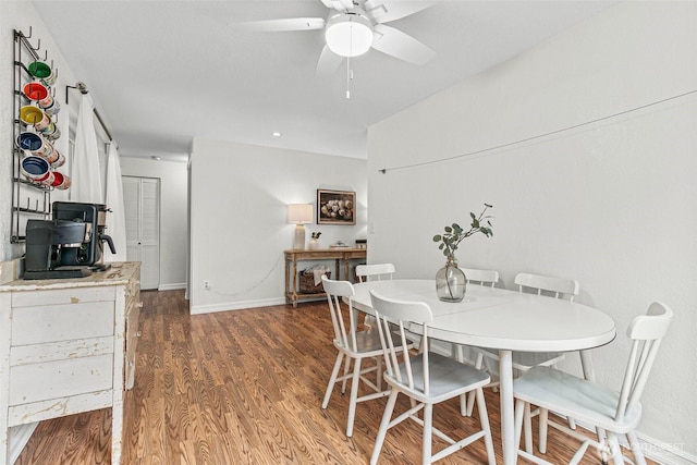 dining room with a ceiling fan, baseboards, and wood finished floors