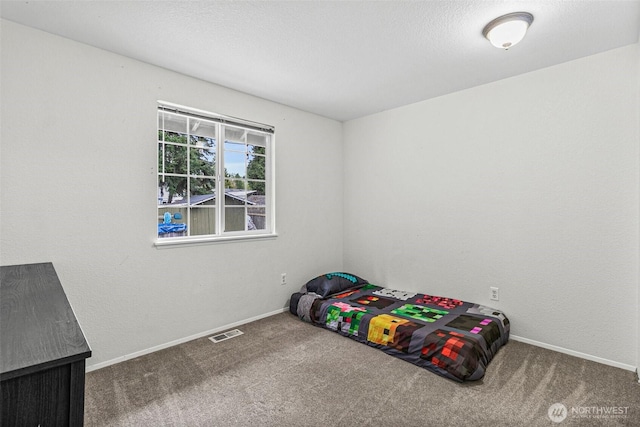 unfurnished bedroom with carpet flooring, baseboards, and visible vents