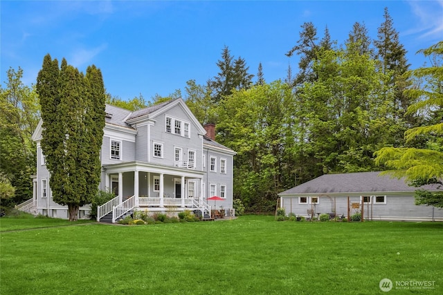 exterior space with covered porch, a yard, and a chimney