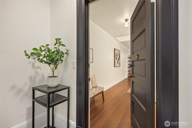hallway with dark wood-type flooring and baseboards