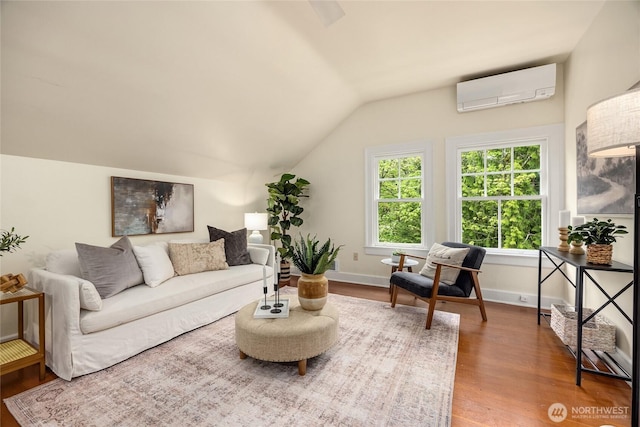 living area with baseboards, vaulted ceiling, a wall mounted air conditioner, and wood finished floors