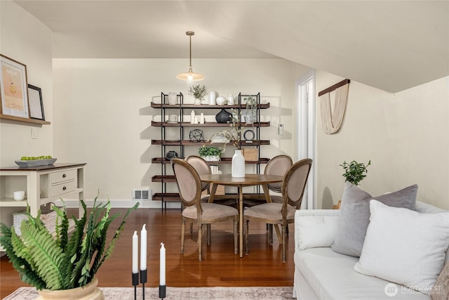 dining space featuring baseboards, wood finished floors, and visible vents