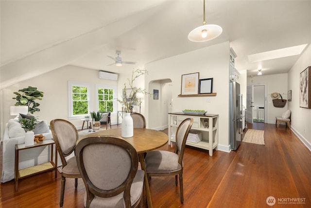 dining area with arched walkways, ceiling fan, a wall unit AC, and dark wood finished floors
