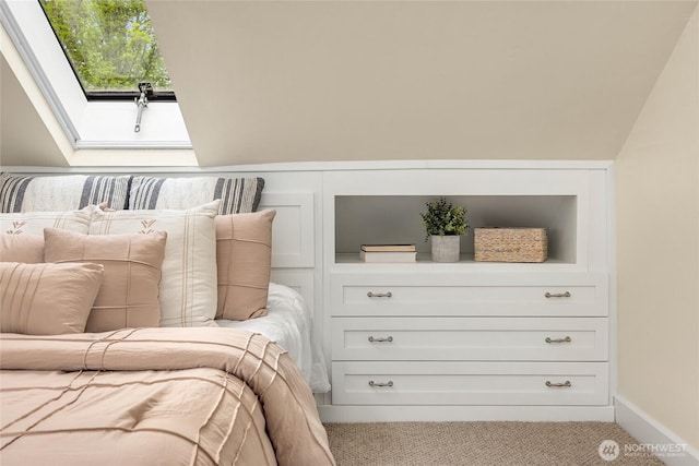 carpeted bedroom featuring a skylight and baseboards