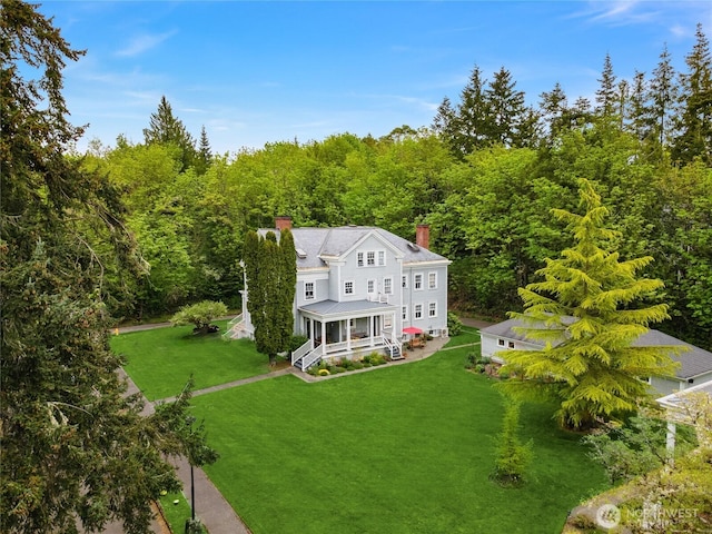 birds eye view of property with a view of trees
