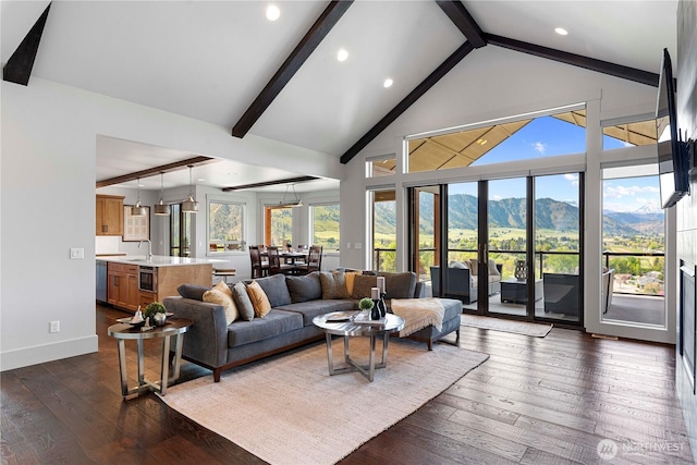 living room featuring beamed ceiling, a healthy amount of sunlight, and dark wood-type flooring