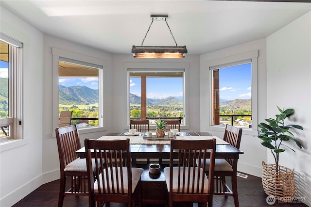 dining room featuring a mountain view, dark wood finished floors, and baseboards