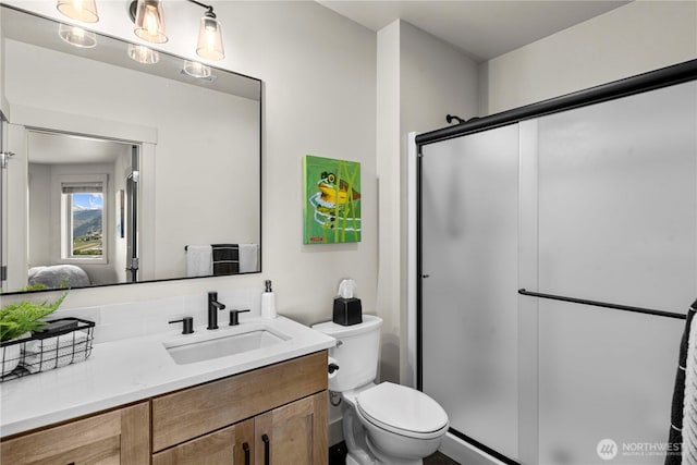 bathroom with toilet, a stall shower, and vanity