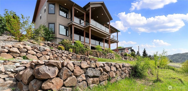 view of property exterior with a mountain view and a balcony