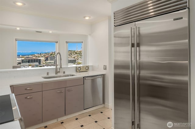 kitchen featuring crown molding, light countertops, a sink, gray cabinetry, and stainless steel appliances
