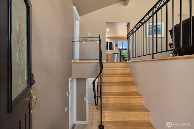 staircase with tile patterned flooring and lofted ceiling