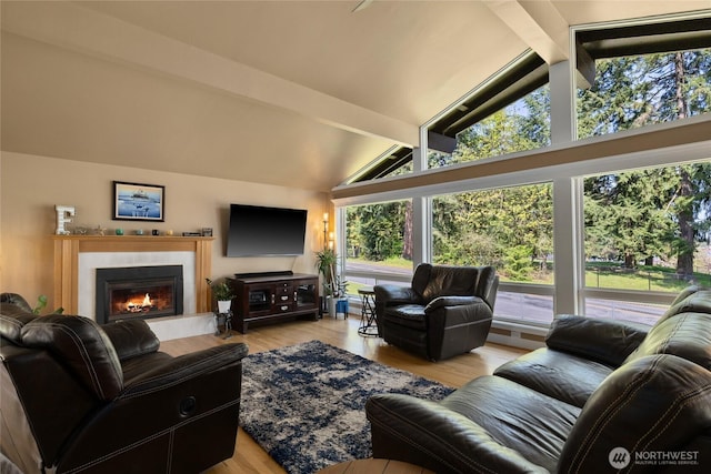 living area with a glass covered fireplace, high vaulted ceiling, beamed ceiling, and wood finished floors