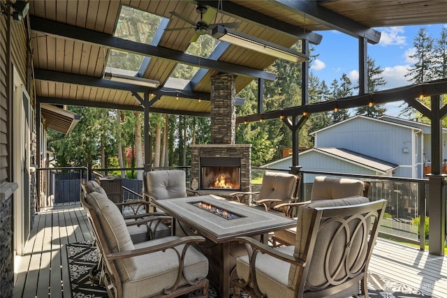 deck featuring a ceiling fan and an outdoor fire pit