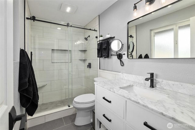 bathroom with toilet, tile patterned floors, a shower stall, and vanity