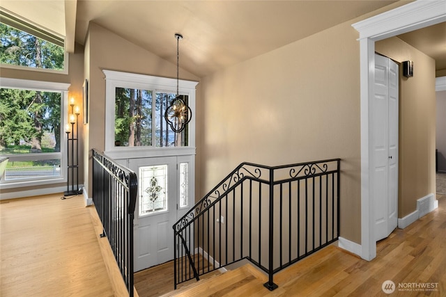 entrance foyer with baseboards, plenty of natural light, wood finished floors, and a notable chandelier