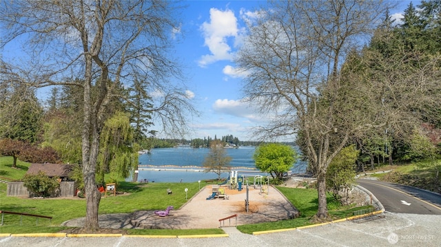 surrounding community with a yard, a water view, and playground community