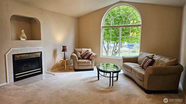 carpeted living room featuring baseboards, vaulted ceiling, and a fireplace