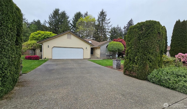 single story home with a garage, a front lawn, and driveway