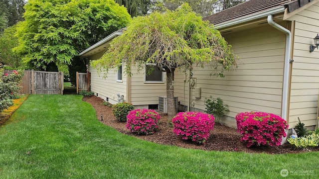 view of side of property featuring a lawn and fence