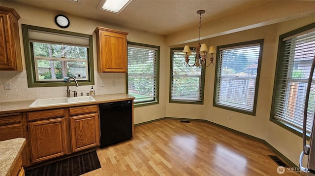 kitchen featuring visible vents, a sink, brown cabinetry, and black dishwasher