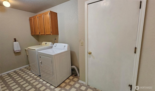 clothes washing area with a textured ceiling, light floors, independent washer and dryer, and cabinet space