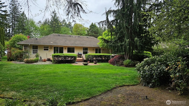 back of house featuring a chimney and a yard