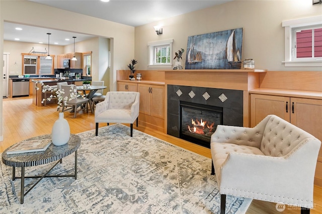 1740 NE Nutkana Way, Poulsbo, WA 98370 - living area with light wood-style flooring, a tiled fireplace, and recessed lighting