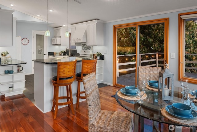 kitchen with recessed lighting, white microwave, dark wood finished floors, and white cabinets