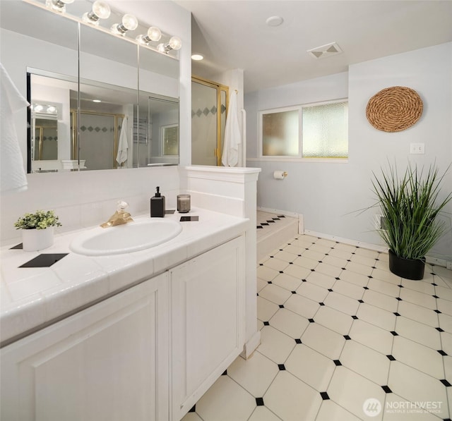 full bathroom featuring tile patterned floors, visible vents, a stall shower, and vanity
