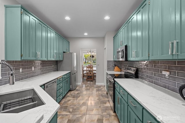 kitchen with recessed lighting, appliances with stainless steel finishes, decorative backsplash, and a sink