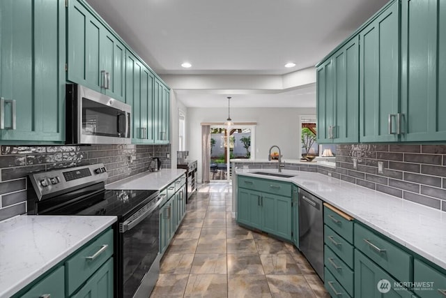 kitchen with green cabinetry, recessed lighting, appliances with stainless steel finishes, and a sink