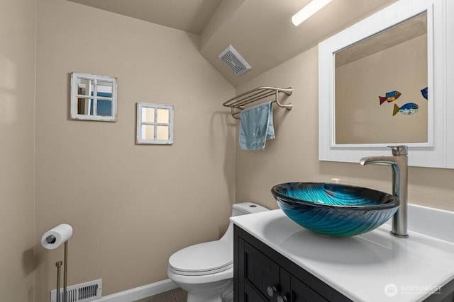 half bathroom with toilet, baseboards, vanity, and visible vents