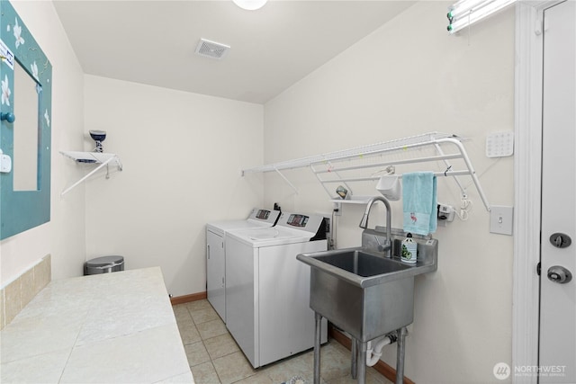 13103 SE 261st Pl, Kent, WA 98030 - laundry area featuring laundry area, visible vents, light tile patterned floors, a sink, and washer and clothes dryer