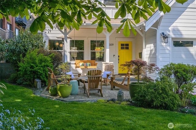 entrance to property with fence, a patio, an outdoor hangout area, and a yard