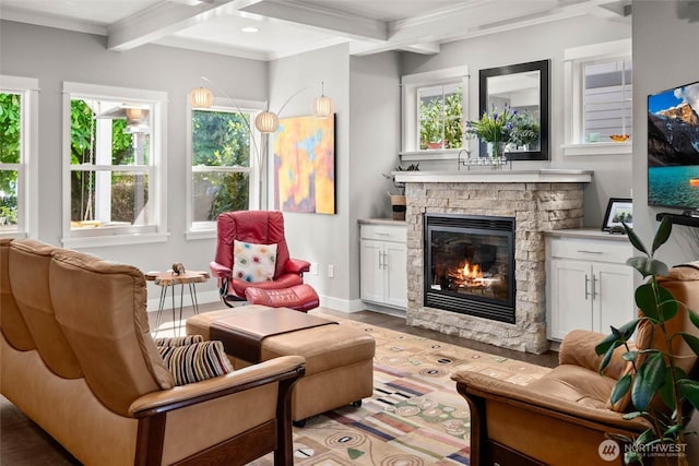 living area featuring baseboards, ornamental molding, beam ceiling, and a fireplace