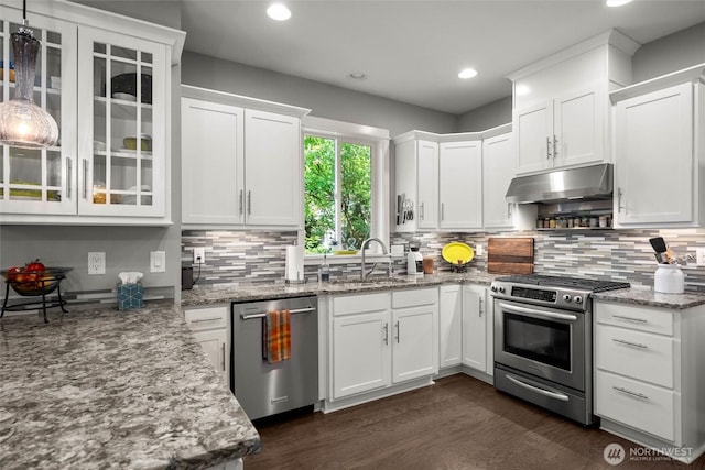 kitchen featuring white cabinets, appliances with stainless steel finishes, light stone counters, a sink, and under cabinet range hood