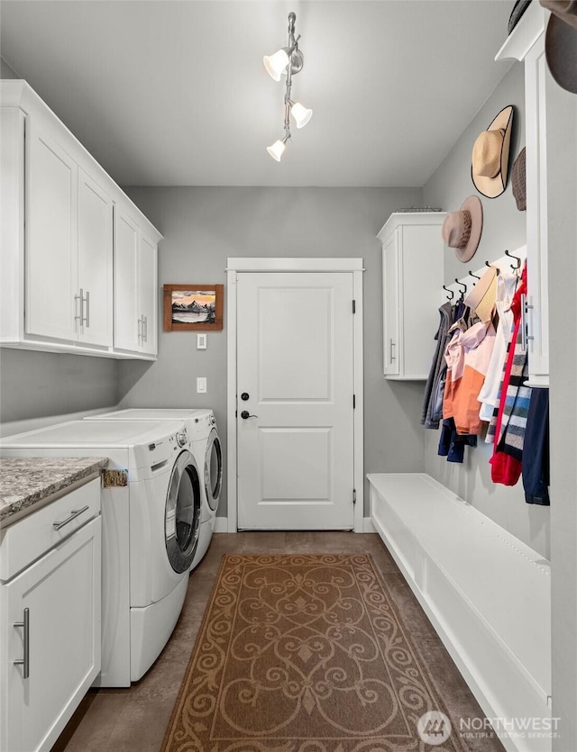 laundry room with cabinet space, separate washer and dryer, rail lighting, and dark tile patterned flooring
