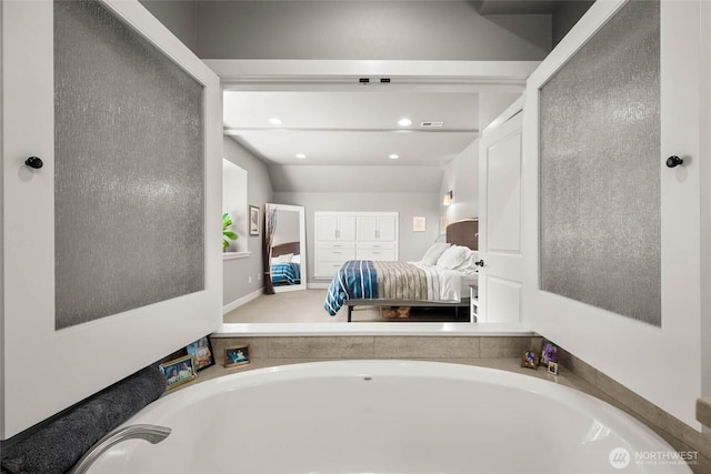ensuite bathroom featuring ensuite bathroom and a garden tub