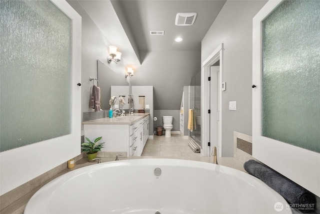 bathroom with toilet, visible vents, a bath, and vanity