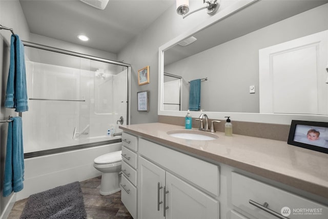 full bathroom featuring vanity, recessed lighting, enclosed tub / shower combo, and toilet