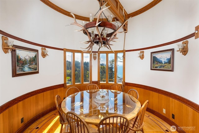 4385 Wildwood Ln, Anacortes, WA 98221 - dining space with wainscoting, wood walls, a chandelier, and light wood-type flooring