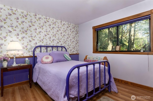 4385 Wildwood Ln, Anacortes, WA 98221 - bedroom featuring wallpapered walls, wood finished floors, a wainscoted wall, and baseboards
